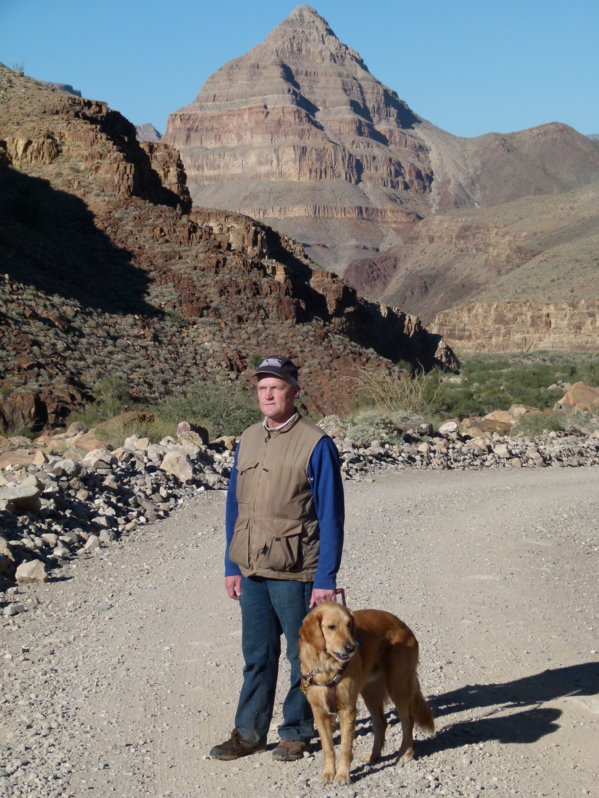 A Seeing Eye graduate stands with his golden retriever Seeing Eye dog in harness at the Grand Canyon National Park.