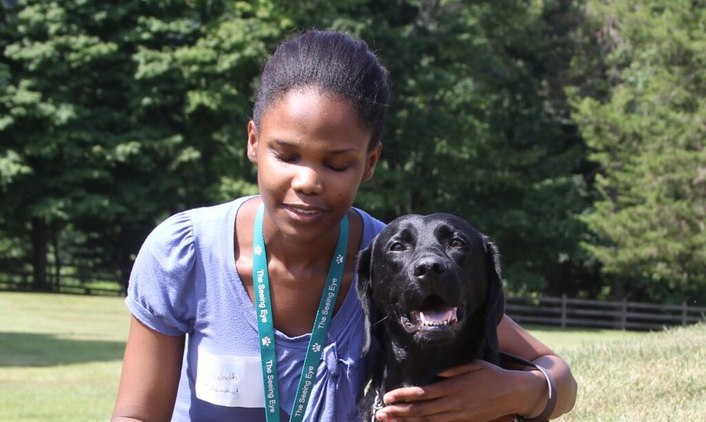 A Seeing Eye graduate with her Seeing Eye dog, a black Labrador retriever.