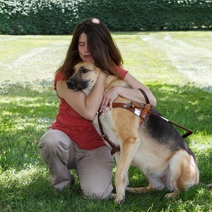 A Seeing Eye graduate hugs her Seeing Eye dog, a German shepherd.