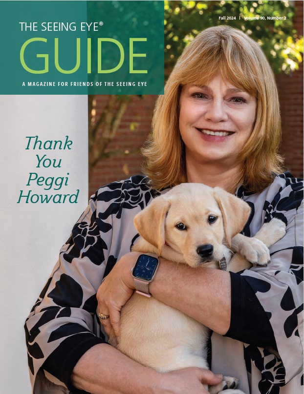 The cover of The Guide Fall 2024 shows President & CEO Peggi Howard holding a yellow Labrador/golden retriever cross puppy.