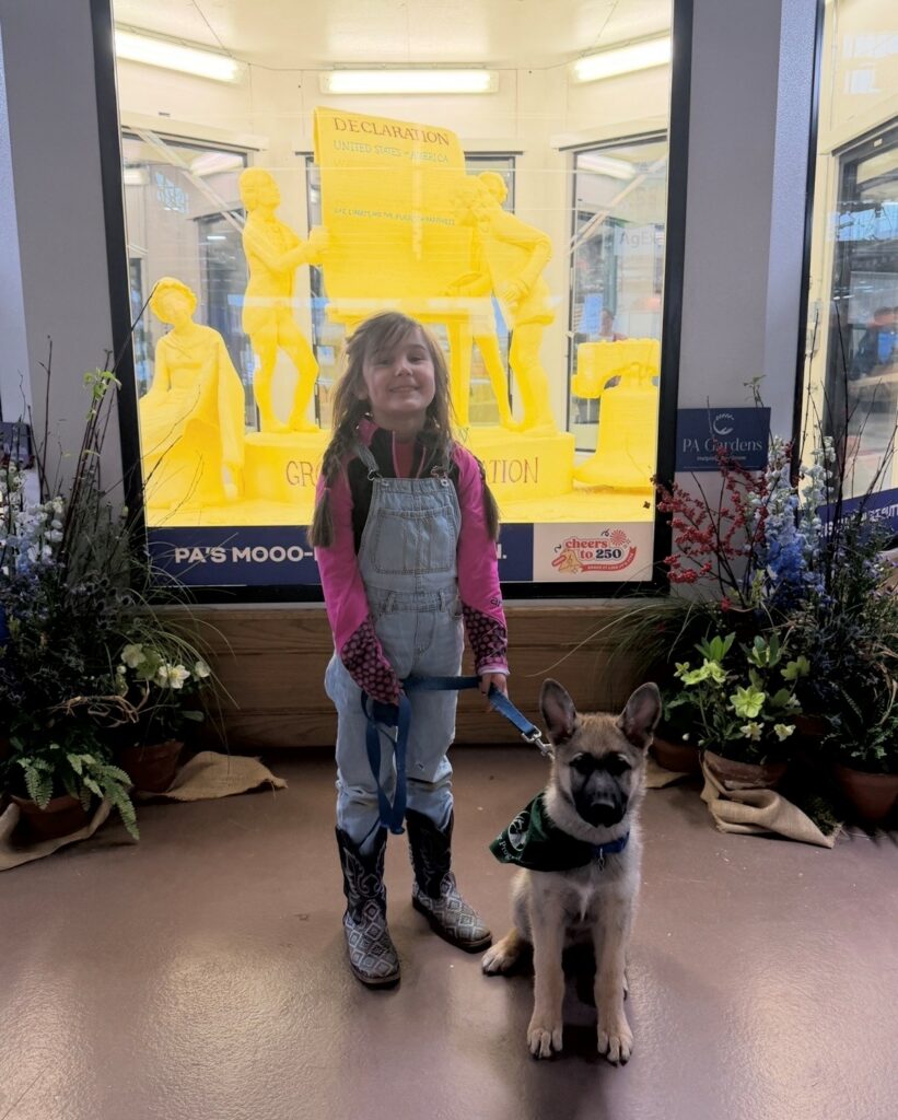 Laura’s daughter stands with a German shepherd puppy her family is raising.